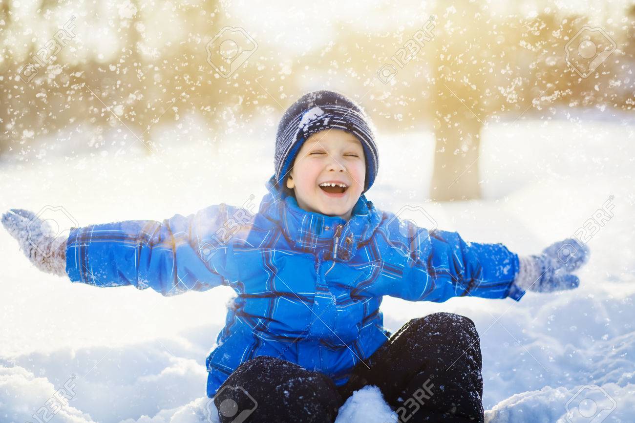 34782403-Laughing-little-boy-sitting-in-the-snow-park--Stock-Photo.jpg