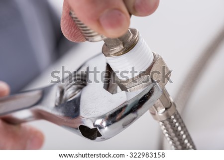 stock-photo-plumber-screwing-plumbing-fittings-closeup-322983158.jpg