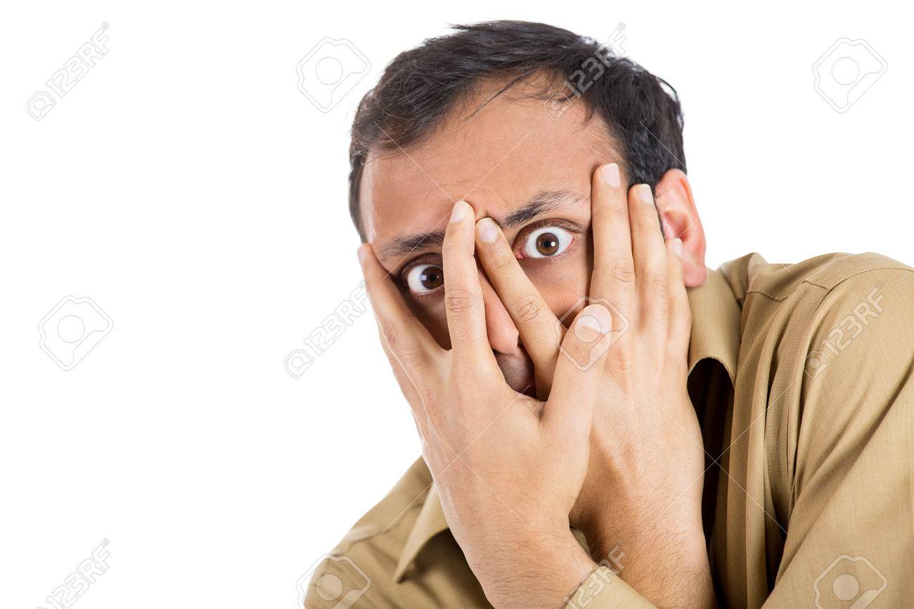 25792771-Closeup-portrait-of-anxious-guy-paranoid-man-covering-his-face-with-hands-looking-through-fingers-ha-Stock-Photo.jpg