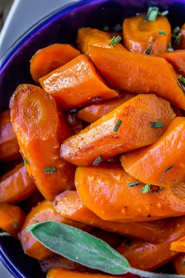 brown butter glazed carrots in a blue bowl.
